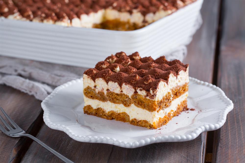 A slice of tiramisu on a white serving plate